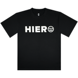 The Hiero Bold Heavy Tee by Hieroglyphics is a black T-shirt with "HIERO" in bold white letters on the chest, inspired by hip-hop culture. It features a face-like white circle with three lines and two dots, round neckline, and short sleeves against a white background.