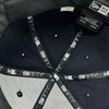 Detailed close-up inside the crown of navy fitted hat with black taping with 59FIFTY New Era wordmark repeated.