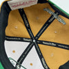 Detailed close up of Mitchell & Ness taping inside crown of two toned brown and green Hiero x Mitchell & Ness Hat.