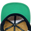 Detailed close up of two toned Hiero x Mitchell & Ness hat with green under visor and Mitchell & Ness taping inside crown.