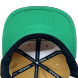 Detailed close up of two toned Hiero x Mitchell & Ness hat with green under visor and Mitchell & Ness taping inside crown.