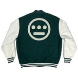 A backside view of a green varsity jacket with white sleeves and green and white striped trim with a large white Hieroglyphics hip-hop logo on the center back.