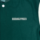 Close-up of white embroidered Hieroglyphics hip-hop logo on the left chest wearside of a green and white varsity jacket.